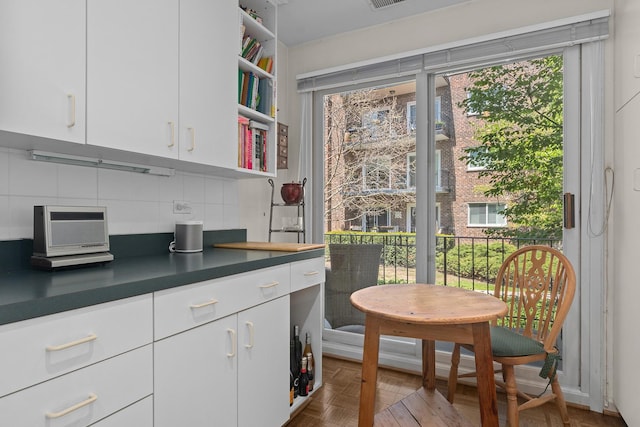 140 Franklin Pl Unit 106, Lake Forest, IL 60045 - kitchen with backsplash, open shelves, white cabinetry, and dark countertops