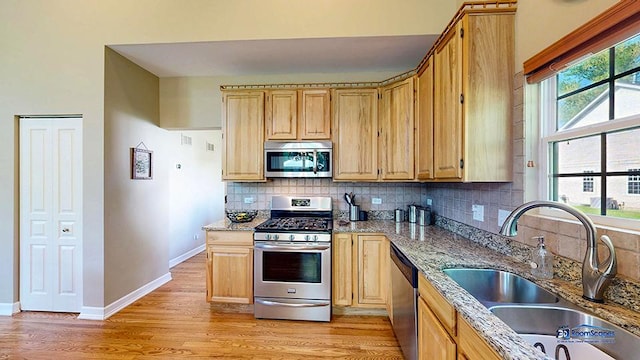 532 Nunda Trl, Crystal Lake, IL 60012 - kitchen featuring stainless steel appliances, a sink, light wood-type flooring, decorative backsplash, and light stone countertops