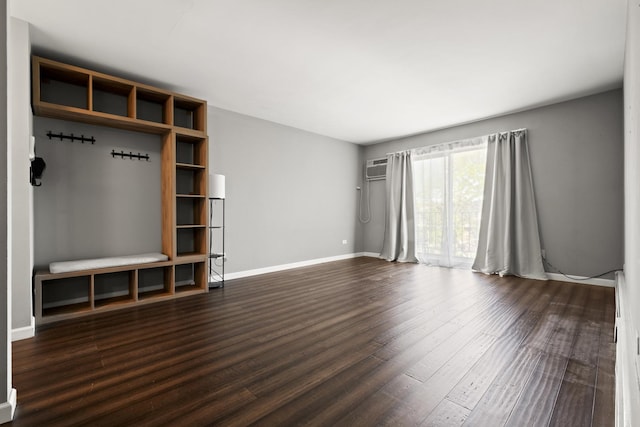 838 Jonathan Ct Unit 305, Prospect Heights, IL 60070 - unfurnished living room featuring dark wood-style flooring, baseboards, and an AC wall unit