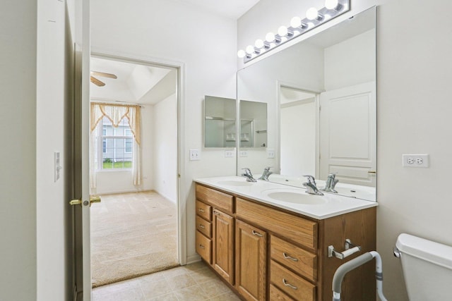 bathroom with toilet, double vanity, ceiling fan, and tile patterned flooring