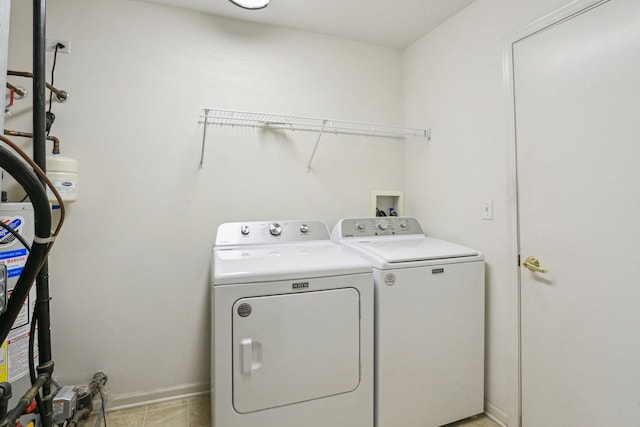 laundry room with washer and dryer and baseboards