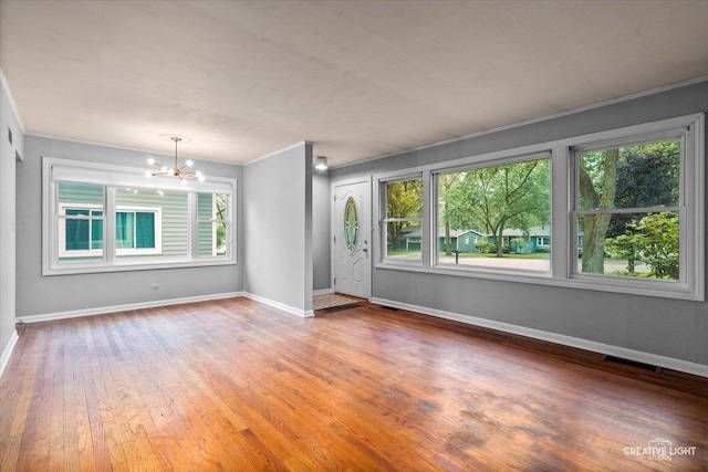 521 Division St, Saint Charles, IL 60174 - spare room featuring plenty of natural light, a chandelier, crown molding, and baseboards