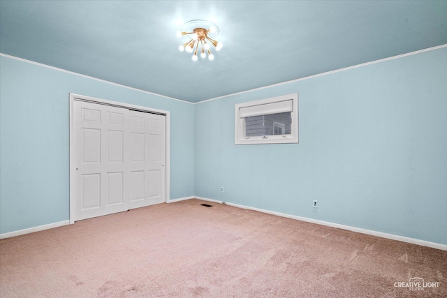 521 Division St, Saint Charles, IL 60174 - unfurnished bedroom featuring carpet, a closet, baseboards, ornamental molding, and a chandelier