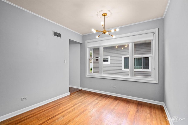 521 Division St, Saint Charles, IL 60174 - unfurnished room featuring a chandelier, ornamental molding, baseboards, and wood finished floors