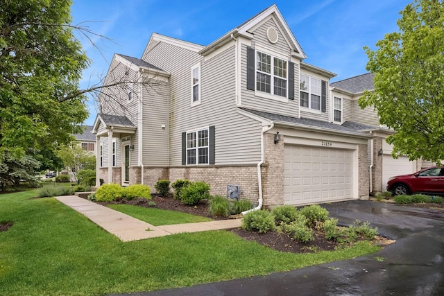 2165 Braeburn Dr Unit A, Wauconda, IL 60084 - view of front of home featuring driveway, a front yard, an attached garage, and brick siding