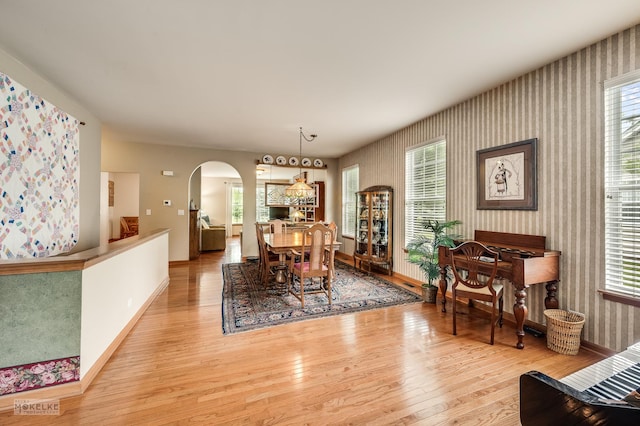 507 Parkland Ct, Oswego, IL 60543 - dining area featuring wallpapered walls, hardwood / wood-style flooring, arched walkways, baseboards, and healthy amount of natural light