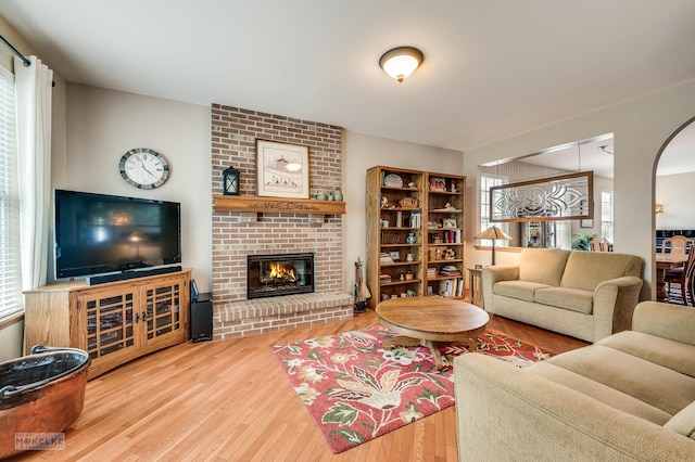 507 Parkland Ct, Oswego, IL 60543 - living area with hardwood / wood-style floors, healthy amount of natural light, a brick fireplace, and arched walkways
