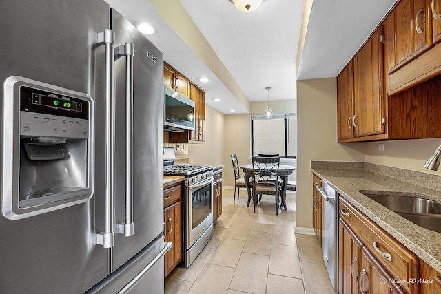 1610 Chippewa Trl, Wheeling, IL 60090 - kitchen featuring appliances with stainless steel finishes, brown cabinetry, a sink, light tile patterned floors, and baseboards
