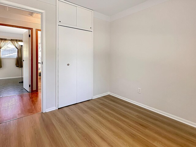 337 E Rose St, Glenwood, IL 60425 - unfurnished bedroom with wood finished floors, baseboards, and a closet