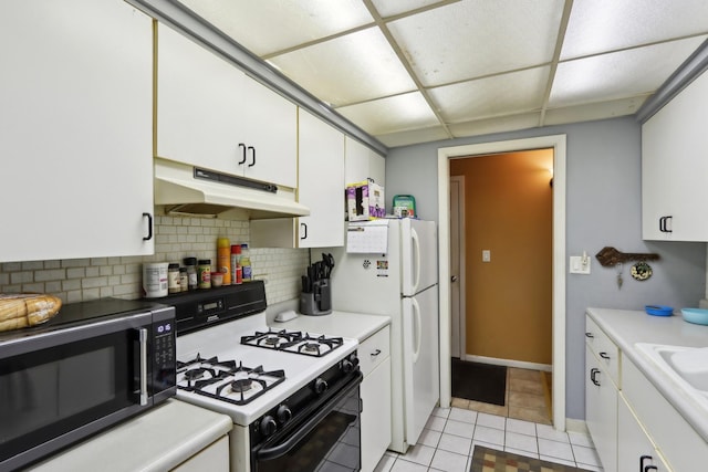 915 Graceland Ave Unit 1E, Des Plaines, IL 60016 - kitchen with under cabinet range hood, black microwave, gas range oven, a paneled ceiling, and white cabinets