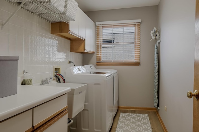 18132 Crystal Ln, Lansing, IL 60438 - laundry area featuring cabinet space, washer and dryer, baseboards, and light wood-style floors