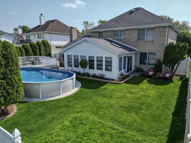 18132 Crystal Ln, Lansing, IL 60438 - rear view of house featuring a deck, an outdoor pool, roof with shingles, and brick siding