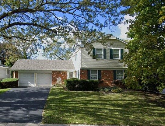 view of front of home featuring a garage, brick siding, asphalt driveway, and a front lawn