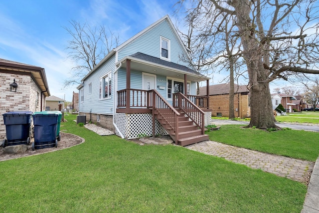 view of front facade with a front lawn, cooling unit, and covered porch