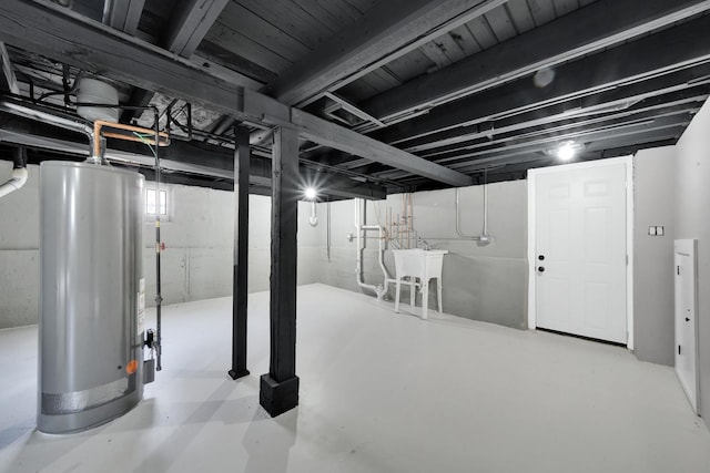 unfinished below grade area with water heater and a sink