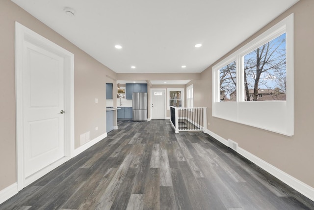 unfurnished living room with dark wood-style floors, baseboards, and recessed lighting