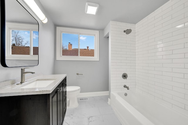 full bathroom with marble look tiles, baseboards, healthy amount of natural light, and toilet