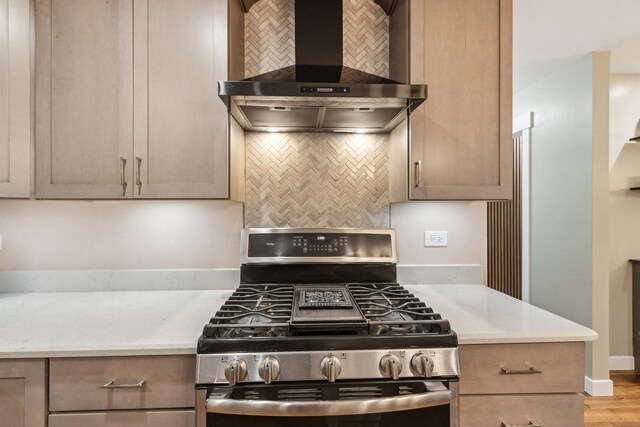 32225 N Pine Ave, Grayslake, IL 60030 - kitchen with stainless steel range with gas stovetop, wall chimney exhaust hood, decorative backsplash, wood finished floors, and baseboards