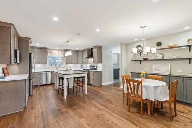 32225 N Pine Ave, Grayslake, IL 60030 - kitchen with stainless steel appliances, wall chimney range hood, a chandelier, dark wood-style flooring, and recessed lighting