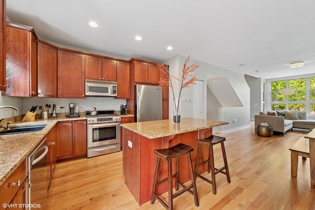 51 E 23rd St Unit 0, Chicago, IL 60616 - kitchen featuring stainless steel appliances, a sink, light wood finished floors, open floor plan, and a breakfast bar