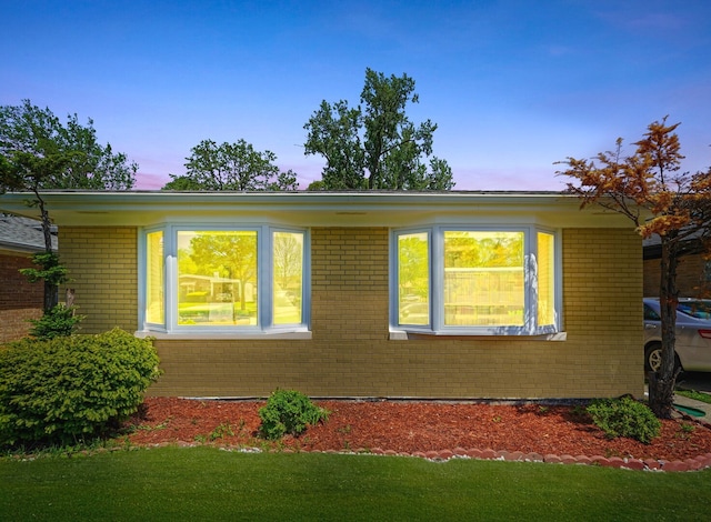 8619 Crawford Ave, Skokie, IL 60076 - property exterior at dusk with brick siding and a lawn