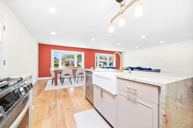8619 Crawford Ave, Skokie, IL 60076 - kitchen with stainless steel appliances, a sink, light wood-style floors, light stone countertops, and recessed lighting
