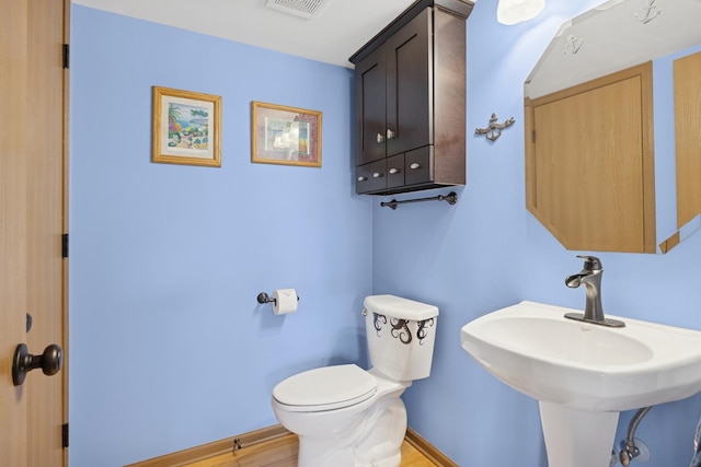 596 N Triumph Ct, Hainesville, IL 60073 - half bath with toilet, baseboards, wood finished floors, and a sink