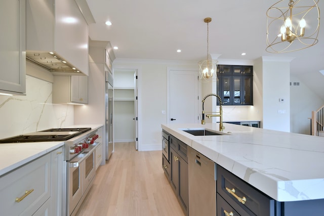 135 Lincoln St, Glenview, IL 60025 - kitchen featuring built in appliances, wall chimney range hood, a sink, a chandelier, and backsplash