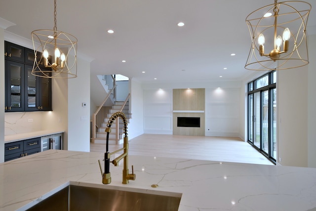 135 Lincoln St, Glenview, IL 60025 - kitchen featuring a chandelier, ornamental molding, a fireplace, glass insert cabinets, and pendant lighting