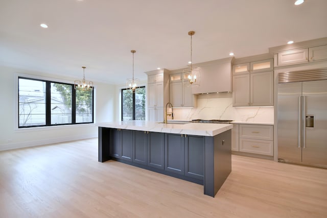 135 Lincoln St, Glenview, IL 60025 - kitchen with appliances with stainless steel finishes, a chandelier, a sink, light wood-style floors, and backsplash