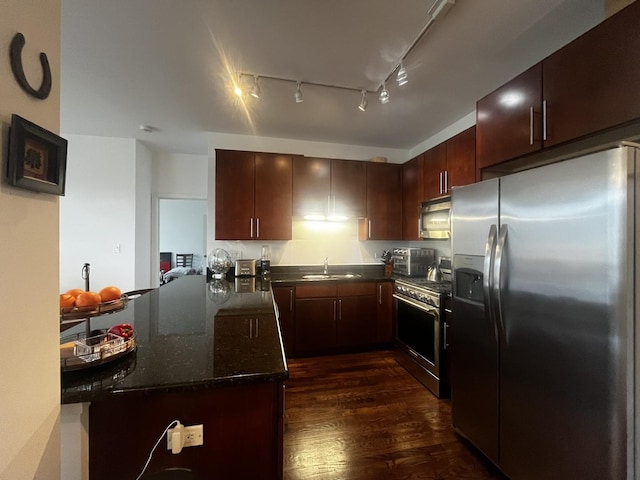 1150 W 15th St Unit 401, Chicago, IL 60608 - kitchen featuring stainless steel appliances, a sink, dark wood finished floors, dark stone counters, and a peninsula