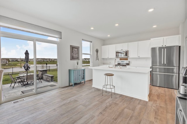 2461 Tahoe Ln, Pingree Grove, IL 60140 - kitchen featuring stainless steel appliances, light wood-style flooring, a center island with sink, light countertops, and recessed lighting