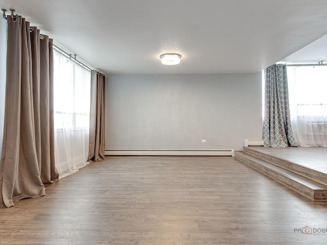 8801 W Golf Rd Unit 6J, Niles, IL 60714 - unfurnished room featuring healthy amount of natural light, wood finished floors, and baseboard heating