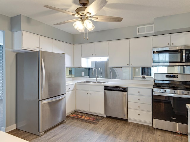 8801 W Golf Rd Unit 6J, Niles, IL 60714 - kitchen with appliances with stainless steel finishes, a sink, light wood-style flooring, and a ceiling fan