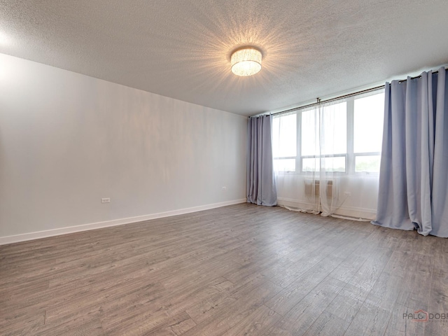 8801 W Golf Rd Unit 6J, Niles, IL 60714 - empty room with a textured ceiling, wood finished floors, and baseboards