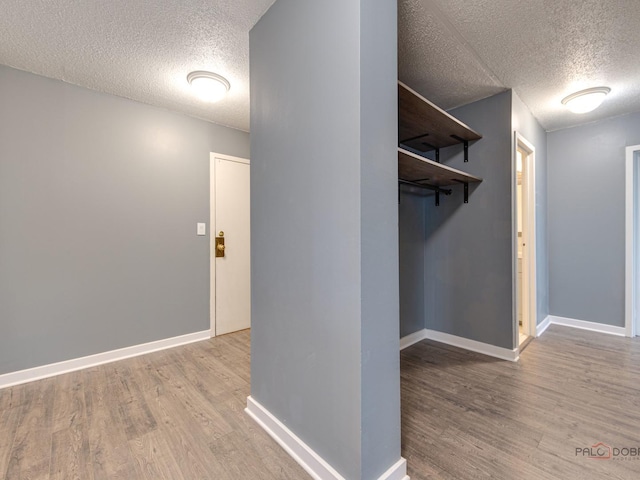 8801 W Golf Rd Unit 6J, Niles, IL 60714 - hall with a textured ceiling, wood finished floors, and baseboards
