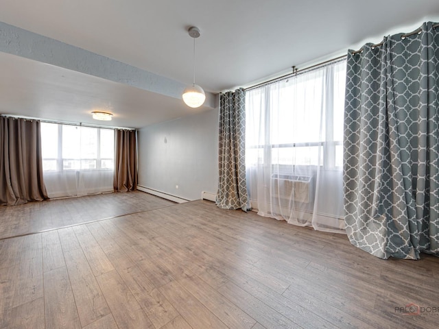 8801 W Golf Rd Unit 6J, Niles, IL 60714 - unfurnished room featuring baseboard heating, hardwood / wood-style floors, baseboards, and a wall mounted air conditioner