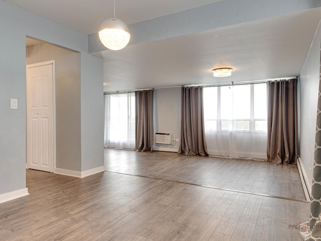 8801 W Golf Rd Unit 6J, Niles, IL 60714 - empty room featuring wood finished floors, a wall mounted AC, and baseboards
