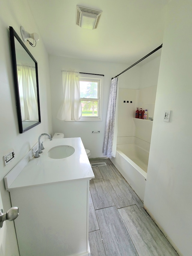 full bathroom with toilet, vanity, shower / tub combo, and wood finished floors