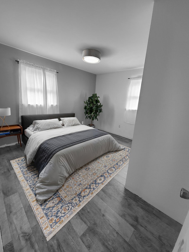 bedroom with multiple windows and wood finished floors
