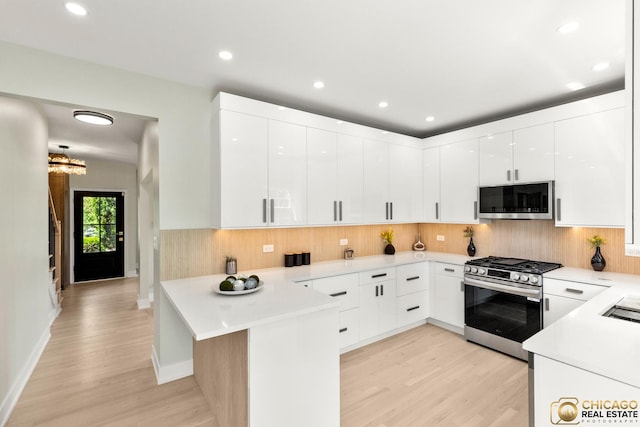 23653 W Ewing Dr, Plainfield, IL 60586 - kitchen featuring appliances with stainless steel finishes, light wood finished floors, a peninsula, decorative backsplash, and recessed lighting