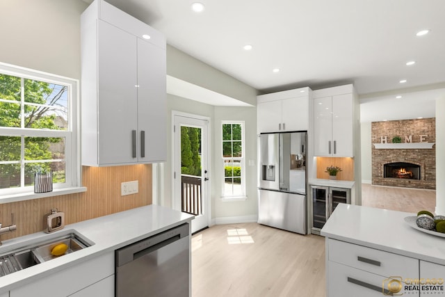 23653 W Ewing Dr, Plainfield, IL 60586 - kitchen with appliances with stainless steel finishes, wine cooler, light countertops, white cabinetry, and modern cabinets