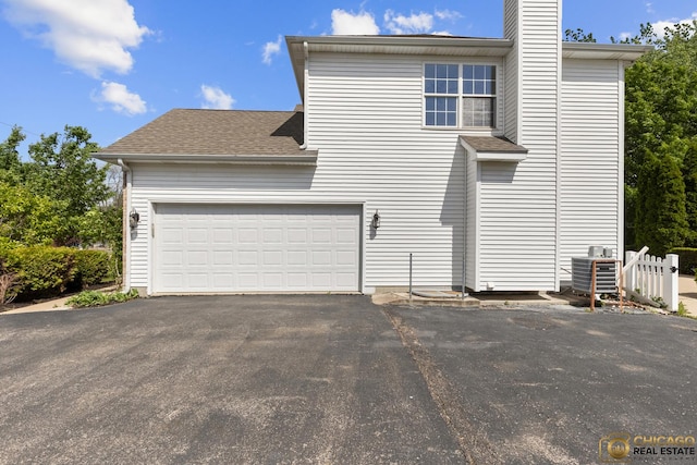 23653 W Ewing Dr, Plainfield, IL 60586 - view of side of property featuring asphalt driveway, central AC unit, a chimney, and roof with shingles
