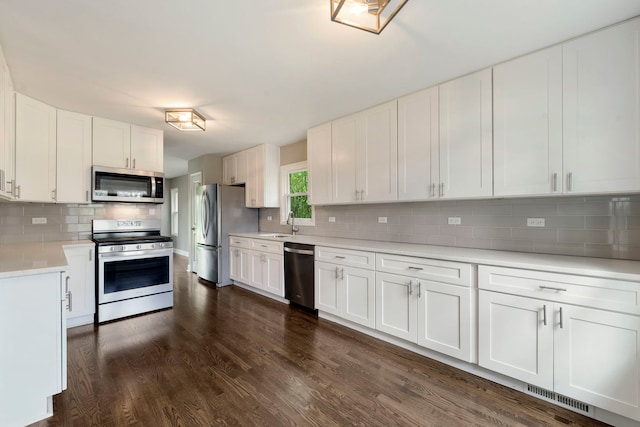 666 Barberry Rd, Highland Park, IL 60035 - kitchen with stainless steel appliances, backsplash, light countertops, dark wood-style flooring, and white cabinetry