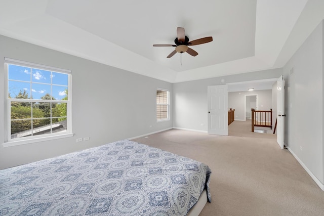 26809 Ashgate Xing, Plainfield, IL 60585 - bedroom with a tray ceiling, light carpet, baseboards, and ceiling fan