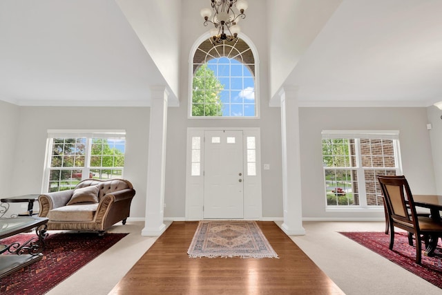 26809 Ashgate Xing, Plainfield, IL 60585 - entrance foyer featuring ornate columns, a chandelier, crown molding, baseboards, and a high ceiling