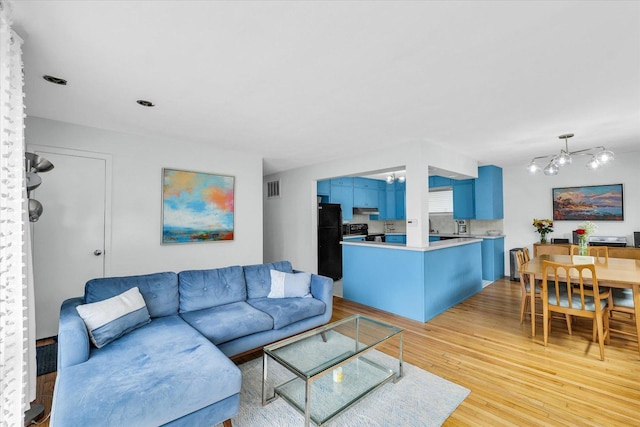1602 Normandy Dr, Champaign, IL 61821 - living room featuring light wood finished floors and a chandelier