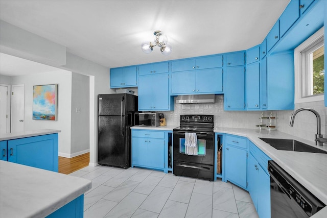 1602 Normandy Dr, Champaign, IL 61821 - kitchen featuring black appliances, blue cabinetry, a sink, under cabinet range hood, and decorative backsplash