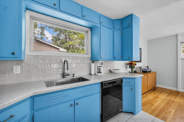 1602 Normandy Dr, Champaign, IL 61821 - kitchen with black dishwasher, blue cabinetry, a sink, and decorative backsplash