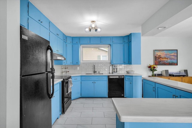 1602 Normandy Dr, Champaign, IL 61821 - kitchen with black appliances, a sink, under cabinet range hood, blue cabinetry, and tasteful backsplash
